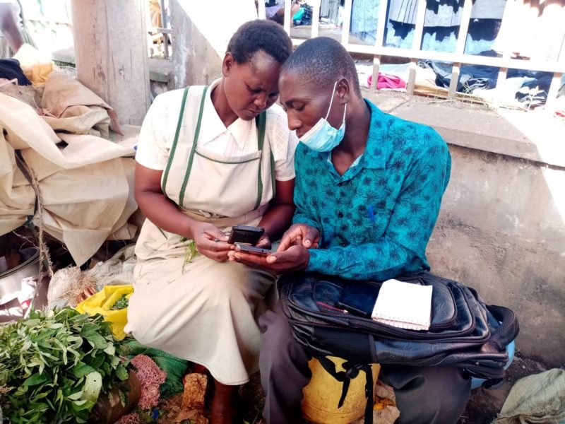 Two people holding mobile phones close to each other