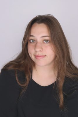 White woman with long brown hair wearing a black shirt