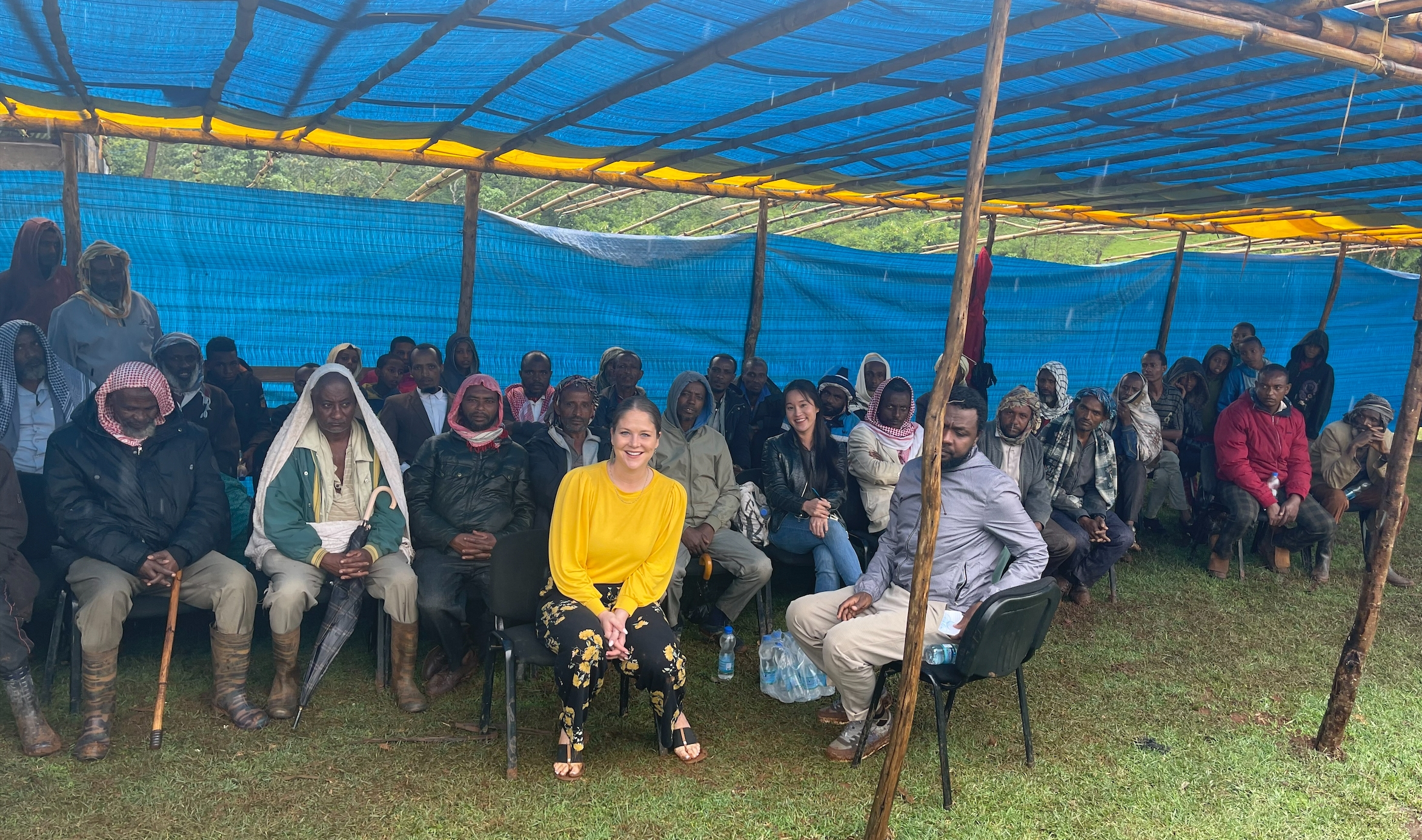 A group of people under a tarp smiling