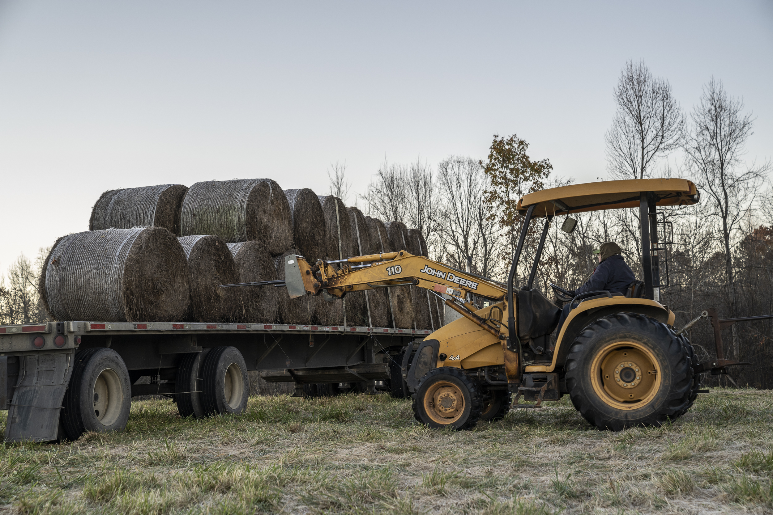 Loader moving hay bales